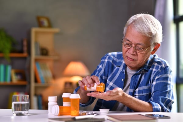 Older man takes medication while using smart phone app 285262292