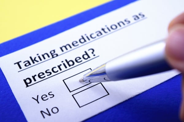 form asking "Taking medication as prescribed?" with pen poised over the yes box 370537934