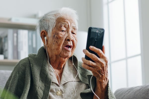 older woman communicates with remote clinical pharmacist via smart phone506406750