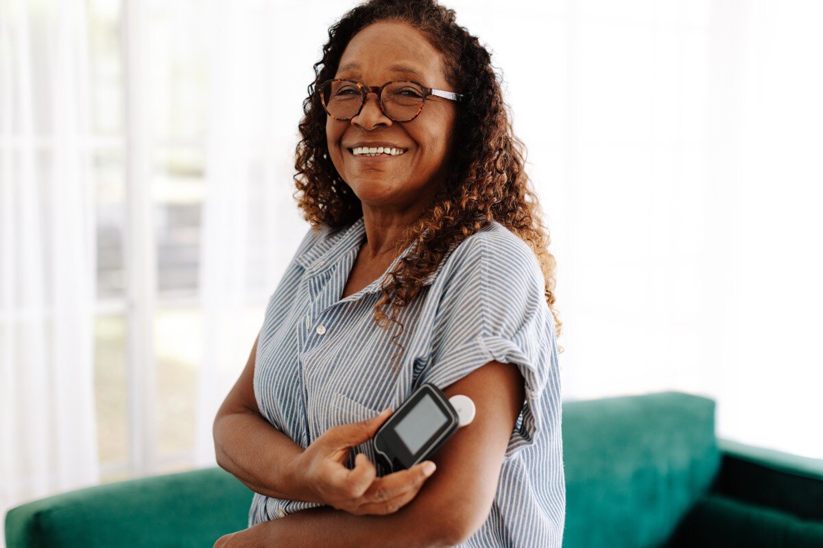 Older woman using glucose monitor at home 600720027