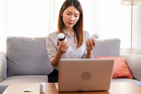 Woman in front of laptop considers medications while using cloud based pharmacy solution 639064148