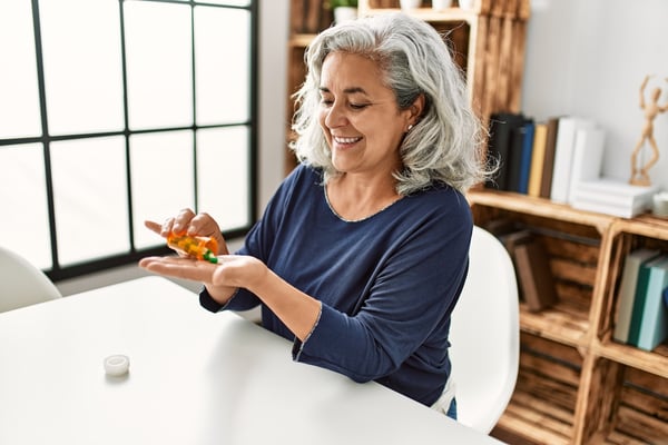 female patient remvoing medication from pill bottle following medication therapy management instructions