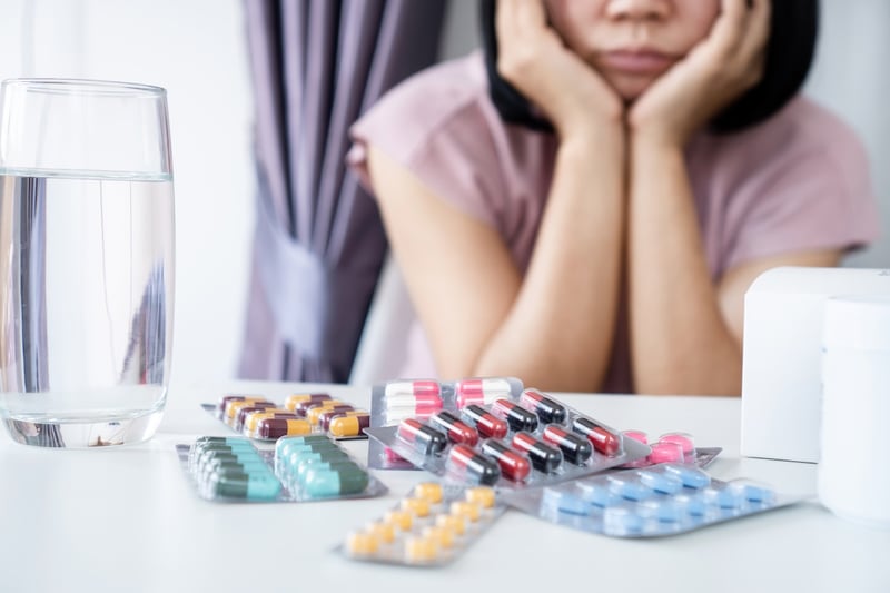 frustrated patient looking at table of various medication types