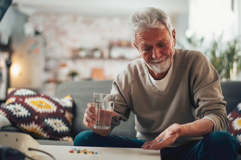 patient sitting on the couch taking medication and following patient engagmenet recommendations