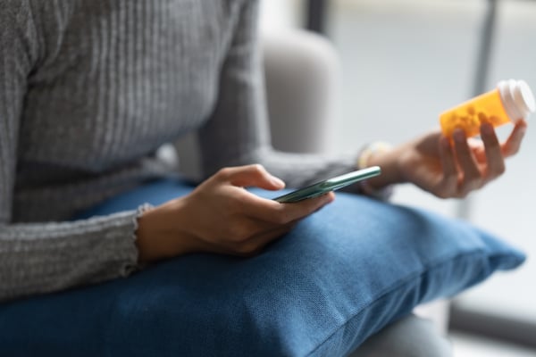 patient using cell phone to review medication details and consult with a remote pharmacist